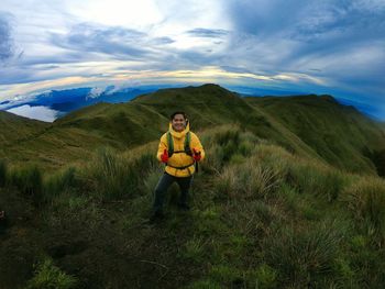 Portrait of man standing on mountain against sky