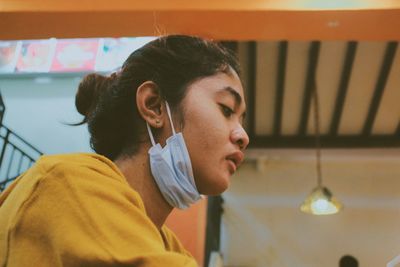 Close-up of young woman wearing surgical mask