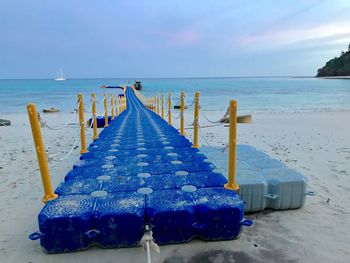 Pier at beach against sky