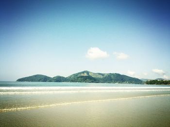 Scenic view of beach against blue sky