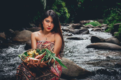 Portrait of young woman sitting outdoors