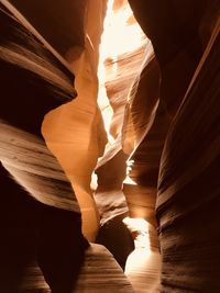 Low angle view of sunlight streaming through rocks
