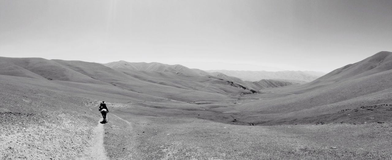 mountain, lifestyles, leisure activity, landscape, full length, men, mountain range, tranquil scene, tranquility, rear view, hiking, scenics, nature, beauty in nature, clear sky, non-urban scene, walking, desert