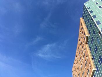 Low angle view of modern building against blue sky