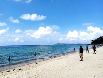 People on beach against sky