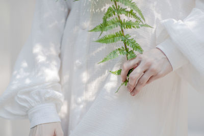 Midsection of woman holding flowering plants