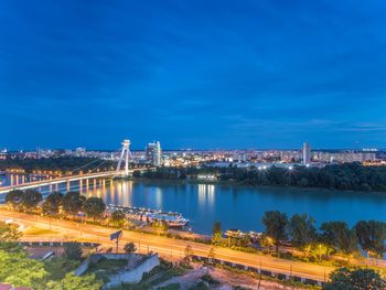 High angle view of illuminated bridge over river against blue sky