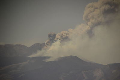 Smoke emitting from volcanic mountain against sky