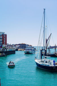Sailboats moored in harbor