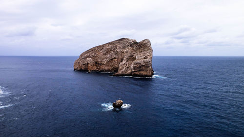 Scenic view of rock formation in sea against sky