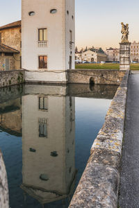 Reflection of buildings in river against sky