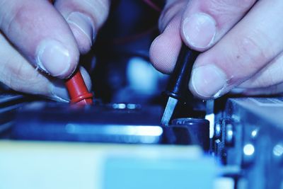 Close-up of human hand testing electronics