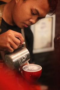 Midsection of man holding coffee cup