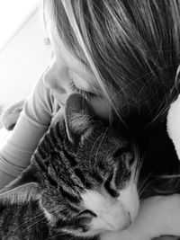 Close-up of girl embracing cat