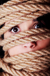 Close-up portrait of woman wrapped in rope