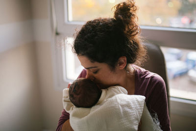 Mother kissing daughter at home