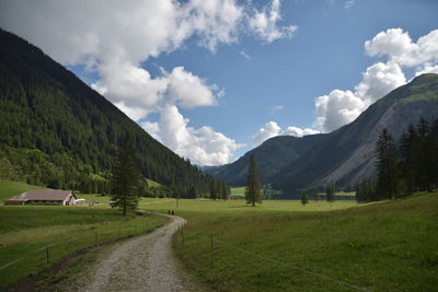 Road amidst field against sky