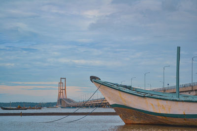 Sailboat moored on beach against sky