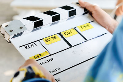 Midsection of man holding film slate while standing outdoors