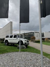 Cars on road by buildings against sky