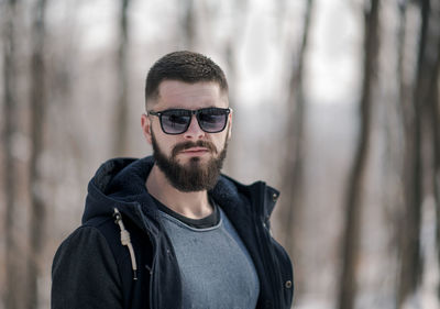 Portrait of young man wearing sunglasses standing outdoors