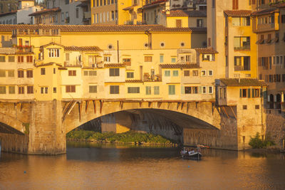 Ponte vecchio over river on sunny day