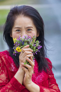 Close-up portrait of a woman with pink flower