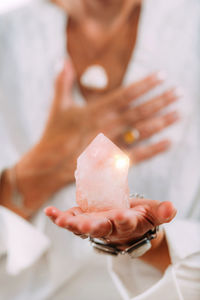 Self-esteem meditation. hand holding a rose quartz crystal, boosting feeling 