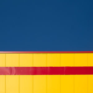 Low angle view of multi colored wall against blue sky