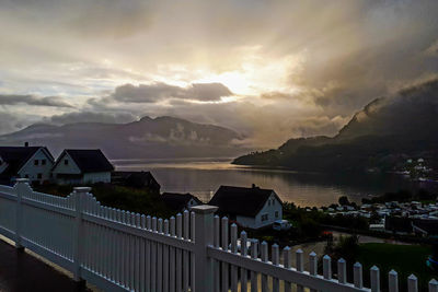 Scenic view of sea and buildings against sky during sunset
