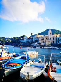 Boats moored in sea against buildings in city