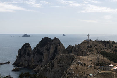 Scenic view of sea by cliff against sky