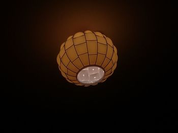 Low angle view of illuminated light bulb over black background