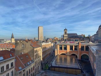 Buildings in city against cloudy sky