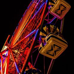 Low angle view of illuminated ferris wheel against sky at night