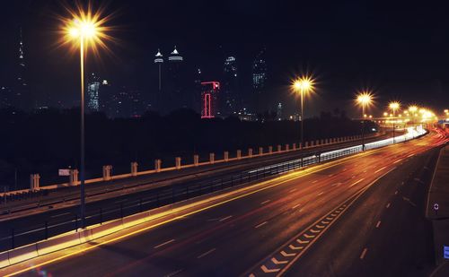 High angle view of light trails on highway against sky at night