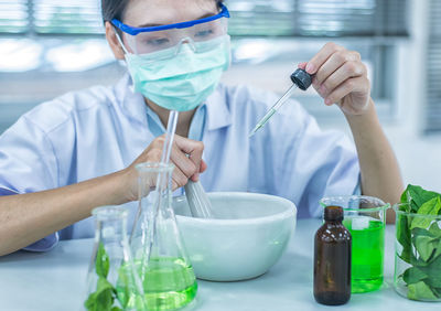 Close-up of female scientist experimenting in laboratory