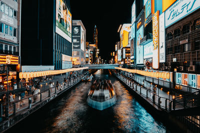 View of canal passing through city at night