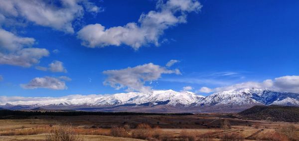 Scenic view of snowcapped mountains against blue sky