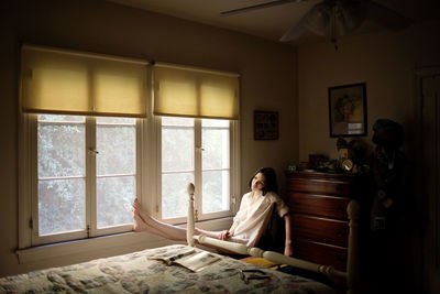 Woman sitting by window at home