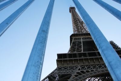 Low angle view of eiffel tower seen through railing against sky