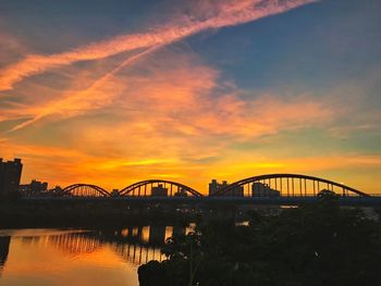 Silhouette bridge against sky at sunset