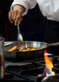 Midsection of man preparing food in kitchen