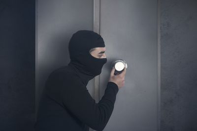 Full length of woman standing against wall