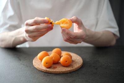Close-up of man holding orange fruits