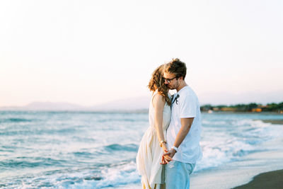 Side view of young woman standing at beach