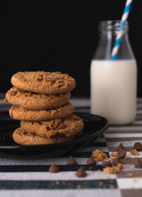 Close-up of cookies on table with milk bottle 