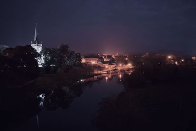 Illuminated city against sky at night