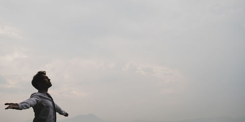 Low angle view of man standing against sky