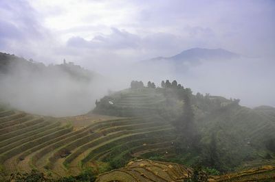 Scenic view of mountains against cloudy sky